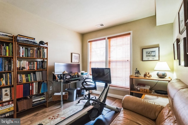 home office featuring baseboards, visible vents, and wood finished floors