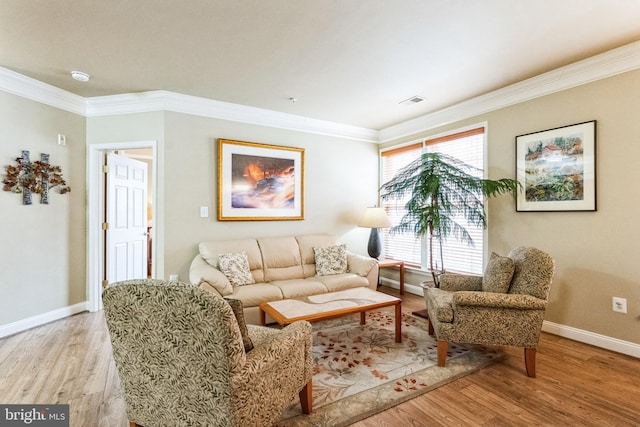 living area featuring ornamental molding, light wood-type flooring, and baseboards