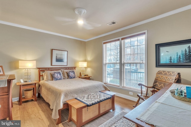 bedroom with baseboards, ornamental molding, visible vents, and light wood-style floors