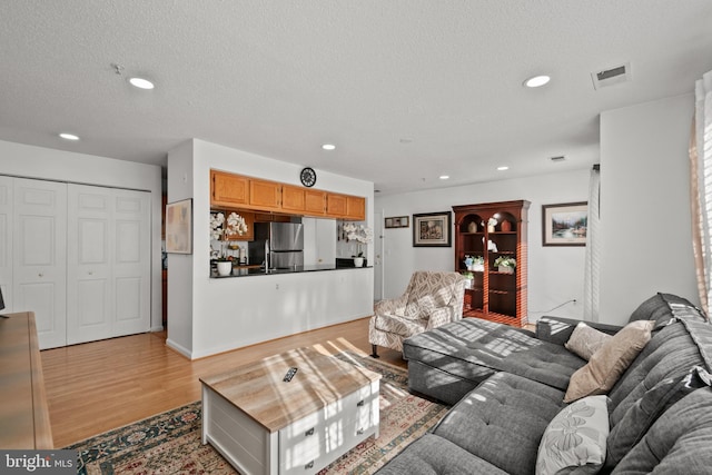 living room with light hardwood / wood-style floors and a textured ceiling