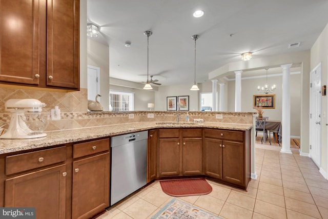 kitchen with hanging light fixtures, ornate columns, dishwasher, and light stone countertops