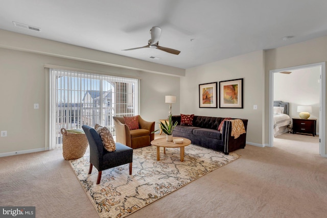 carpeted living room with ceiling fan