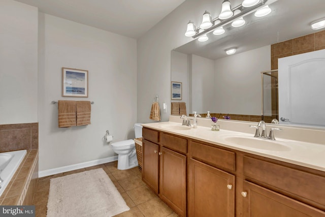 bathroom featuring tile patterned floors, toilet, vanity, and tiled tub