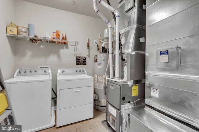 laundry room featuring washer and dryer, gas water heater, and light tile patterned floors