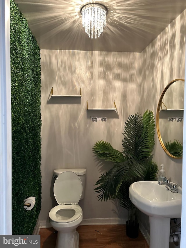 bathroom with sink, a notable chandelier, and toilet