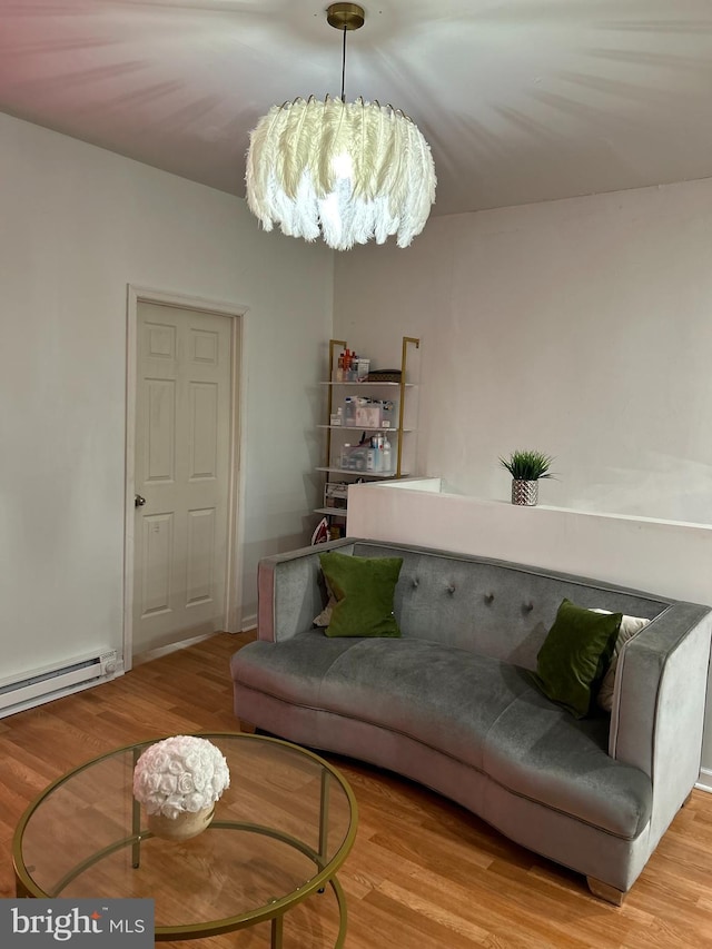 living room with a baseboard heating unit, a notable chandelier, and light wood-type flooring