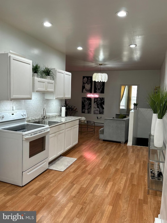 kitchen featuring white electric range oven, sink, white cabinetry, light hardwood / wood-style flooring, and decorative backsplash