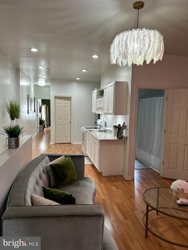 living room with light hardwood / wood-style flooring and a chandelier