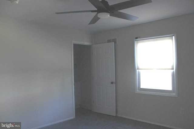 unfurnished bedroom featuring carpet floors, visible vents, multiple windows, and baseboards