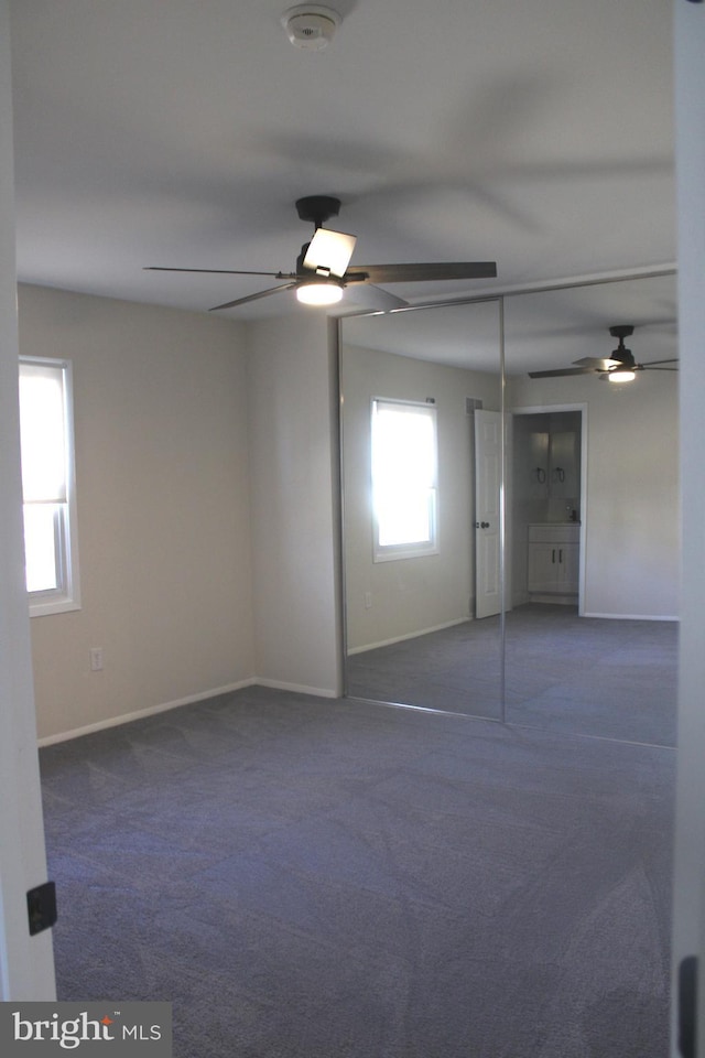 empty room featuring carpet floors, ceiling fan, and baseboards