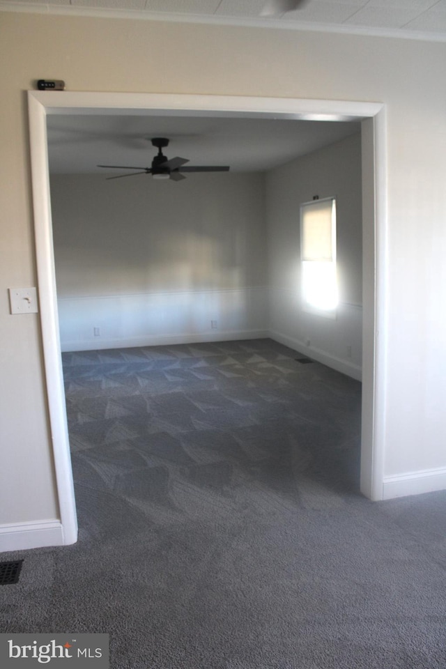 empty room with a ceiling fan, carpet, and baseboards