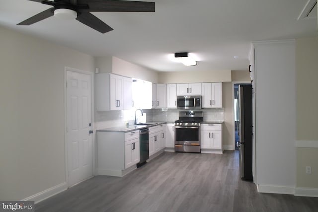 kitchen with stainless steel appliances, white cabinetry, baseboards, dark wood-style floors, and tasteful backsplash