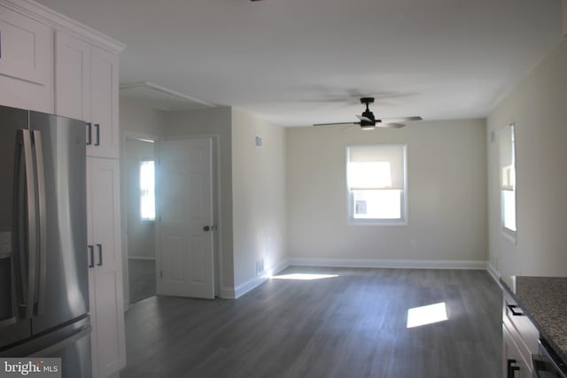 interior space featuring dark wood-type flooring, a ceiling fan, and baseboards