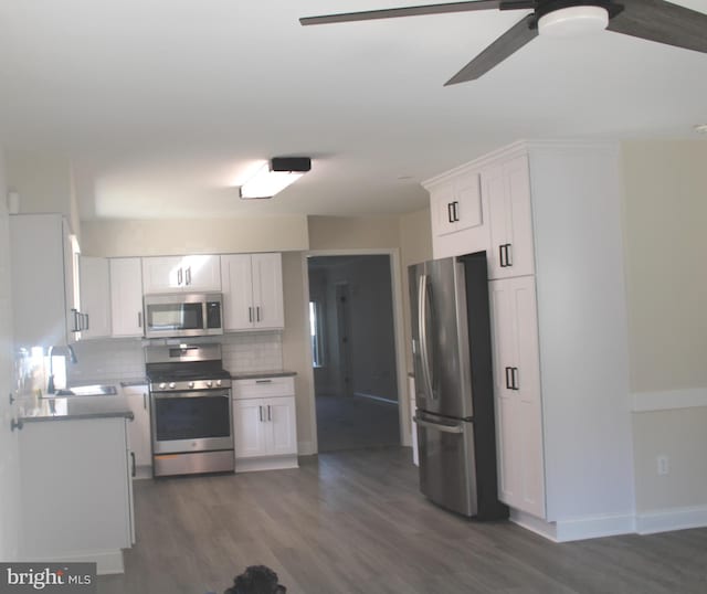 kitchen with ceiling fan, dark wood-style flooring, white cabinetry, appliances with stainless steel finishes, and tasteful backsplash