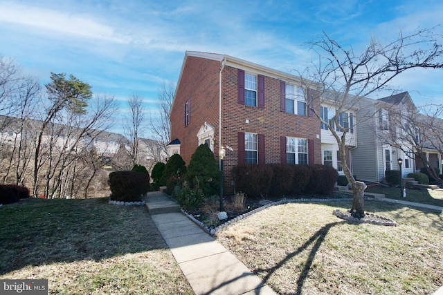 view of front of house with brick siding and a front yard