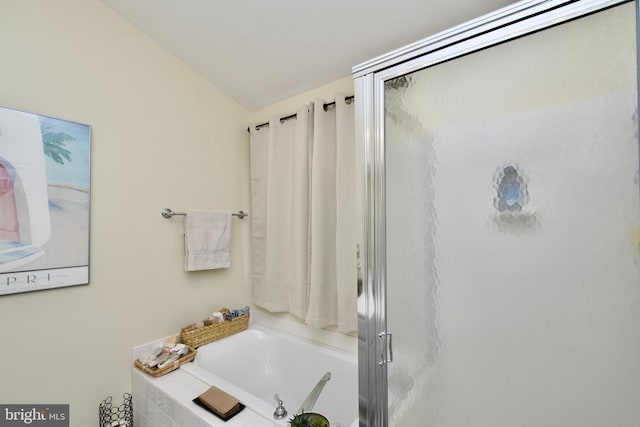 full bathroom featuring lofted ceiling, a shower stall, and a bath