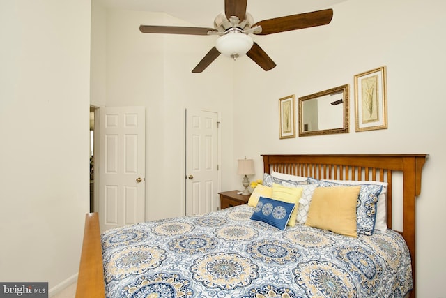 bedroom featuring carpet floors, ceiling fan, and a high ceiling