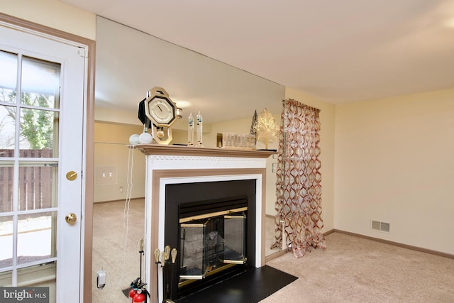 details with a fire extinguisher, carpet flooring, a fireplace with flush hearth, visible vents, and baseboards