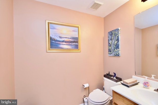 bathroom featuring visible vents, vanity, and toilet