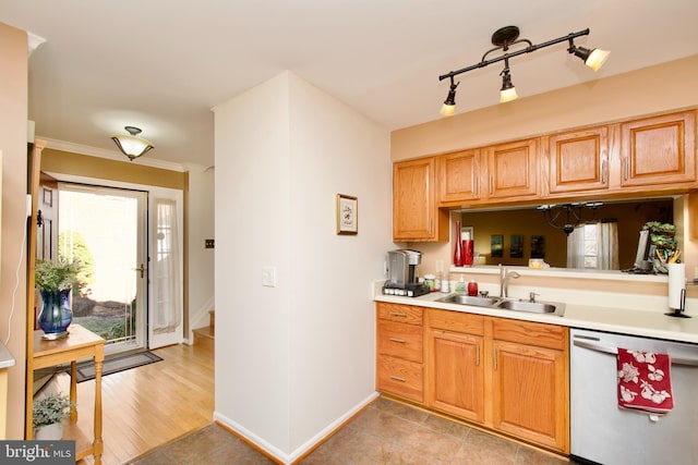 kitchen with dishwashing machine, light countertops, ornamental molding, a sink, and baseboards