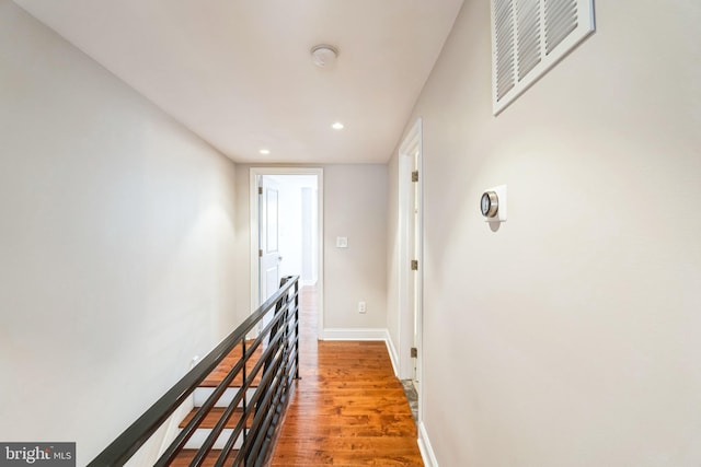 hall featuring recessed lighting, visible vents, baseboards, and wood finished floors