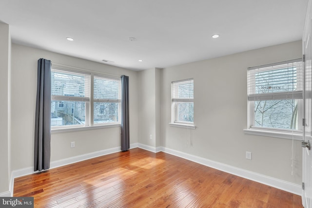 spare room featuring recessed lighting, light wood-style flooring, and baseboards