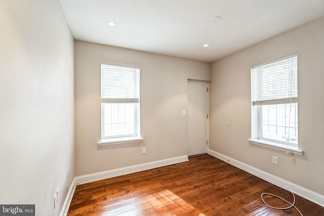 empty room featuring recessed lighting, wood finished floors, and baseboards