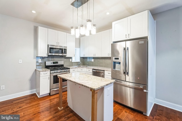 kitchen with appliances with stainless steel finishes, baseboards, light stone counters, and decorative backsplash