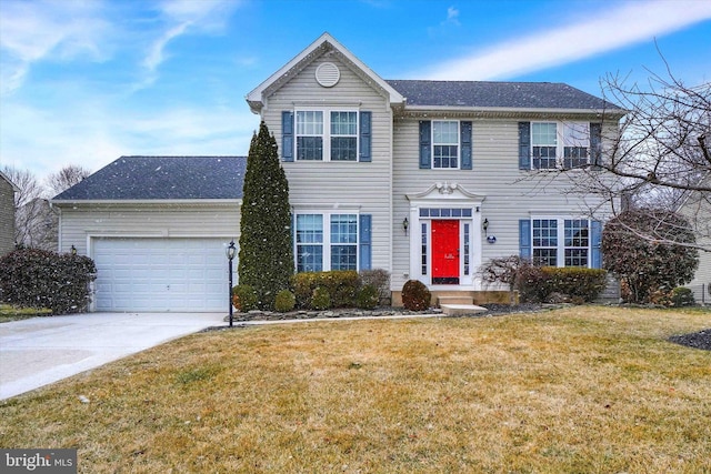 colonial home with an attached garage, concrete driveway, and a front yard