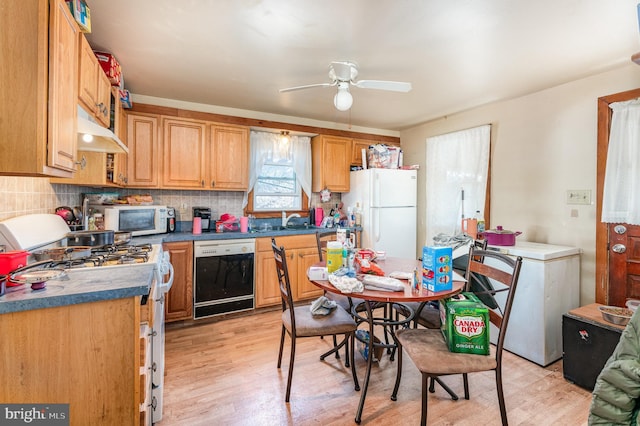 kitchen with sink, white appliances, light hardwood / wood-style flooring, ceiling fan, and decorative backsplash