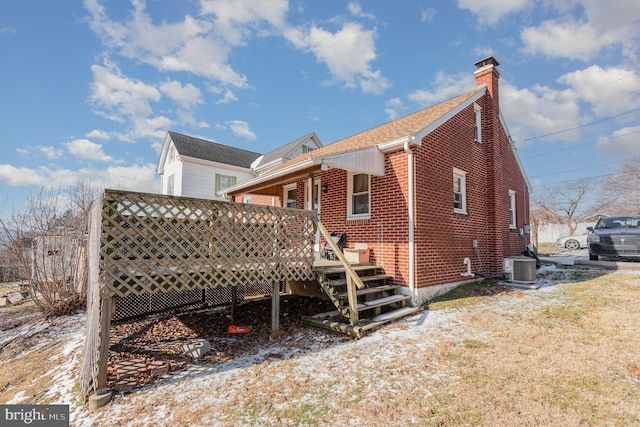 rear view of house with central AC and a deck