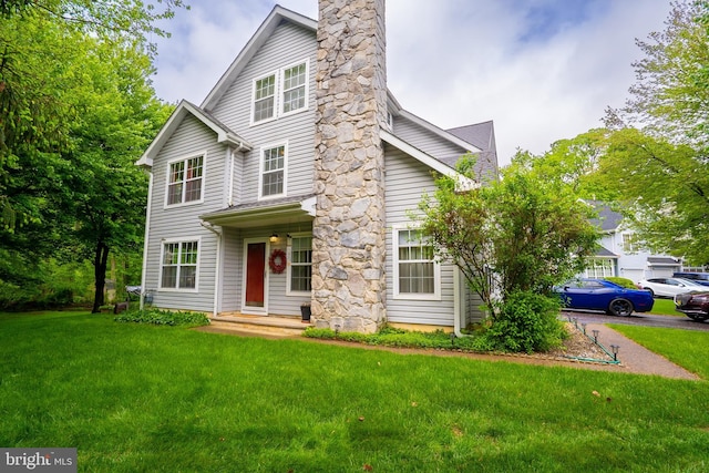 view of front facade featuring a front lawn and a chimney
