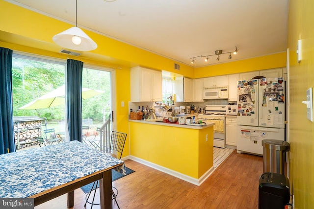 kitchen featuring white appliances, white cabinetry, light wood finished floors, crown molding, and a peninsula