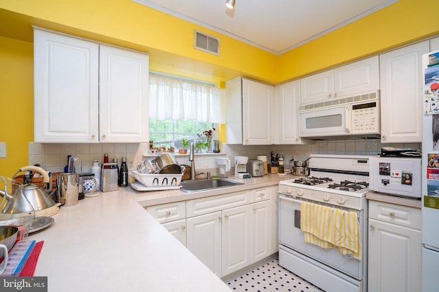 kitchen with white appliances, white cabinetry, light countertops, and decorative backsplash