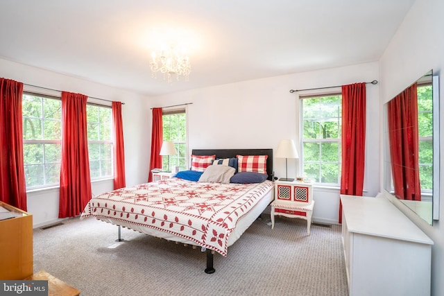 carpeted bedroom with a chandelier and baseboards