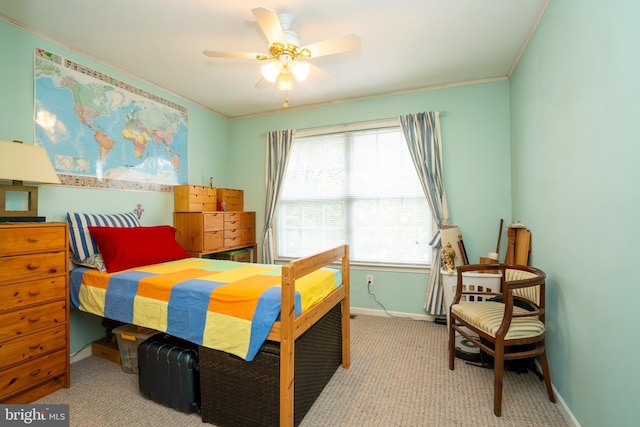 carpeted bedroom with baseboards, crown molding, and ceiling fan