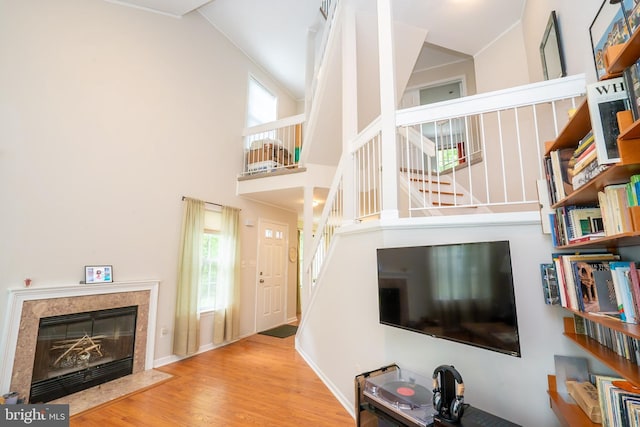 living area featuring stairway, wood finished floors, plenty of natural light, and a high end fireplace