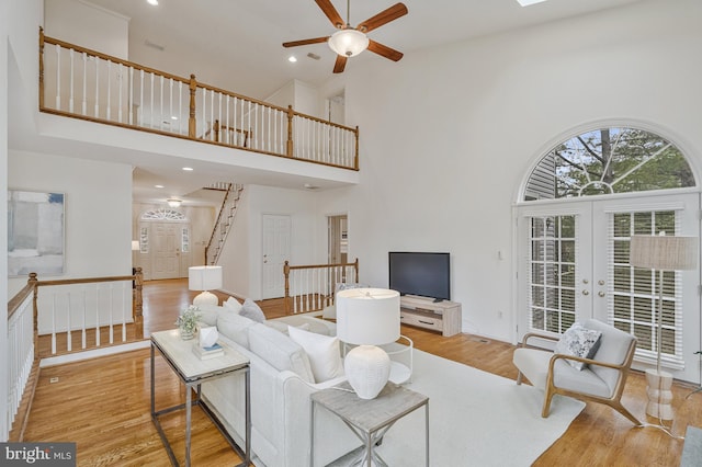 living area featuring ceiling fan, recessed lighting, stairway, a towering ceiling, and wood finished floors