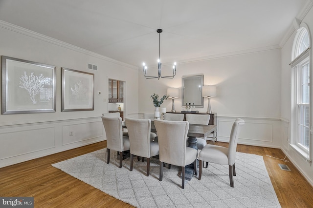 dining space featuring a notable chandelier, visible vents, and wood finished floors