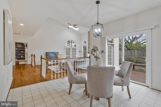 dining space featuring visible vents, a wealth of natural light, light tile patterned floors, and ceiling fan with notable chandelier