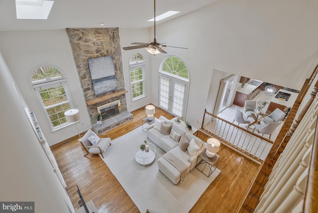 living area with a skylight, wood finished floors, and a fireplace