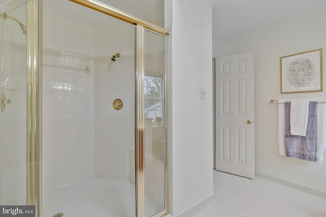 full bath featuring a shower stall, tile patterned flooring, and baseboards