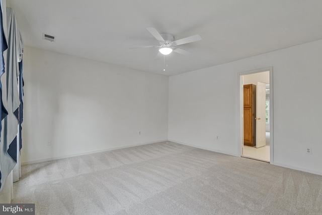 carpeted empty room with visible vents, baseboards, and ceiling fan