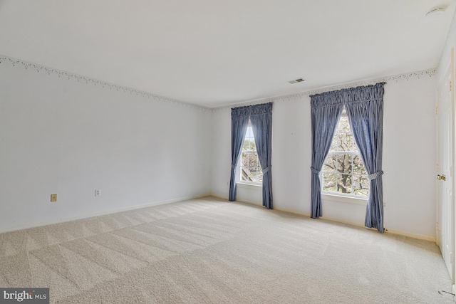 carpeted empty room featuring visible vents