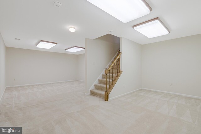 below grade area featuring stairway, carpet flooring, and baseboards