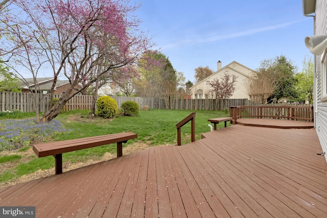 wooden terrace with a fenced backyard and a lawn