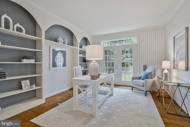 home office with french doors, wood finished floors, ornamental molding, and built in shelves