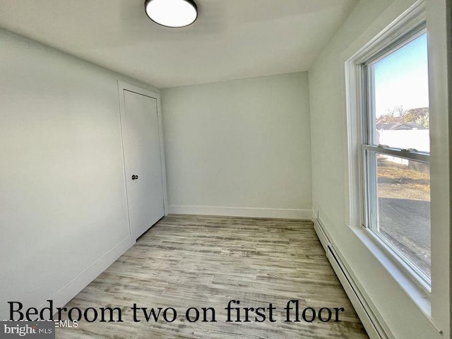 empty room featuring light hardwood / wood-style floors and a baseboard radiator