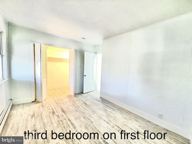 spare room featuring light hardwood / wood-style floors and a baseboard radiator