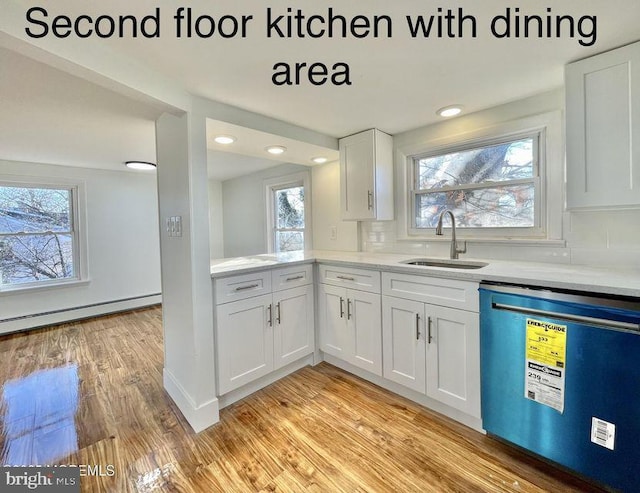 kitchen with sink, light wood-type flooring, white cabinetry, dishwasher, and baseboard heating